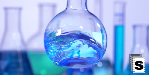 Blue Liquid Mixing in Science Lab Flask