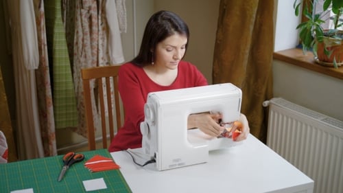 The Woman Works for a Sewing Machine in the Atelier, the Lady Makes the Details of the Clothes
