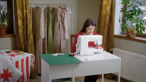 A Woman Works for a Sewing Machine in Her Nebolshom Atelier, a Lady Makes Dresses, She Is a Designer