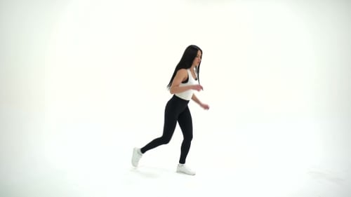 Atlética, joven y hermosa mujer morena con cabello largo, ejercicios de calentamiento en estudio sobre un blanco
