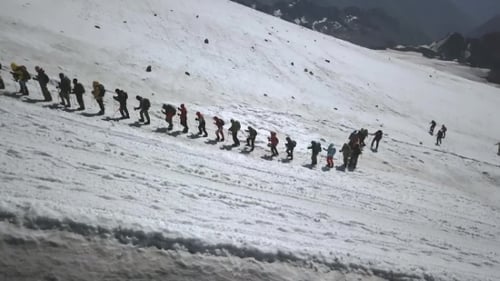 Luftaufnahme einer Wandergruppe in einem Berg auf einem Schneeweg. Extremes Wandern in den Bergen