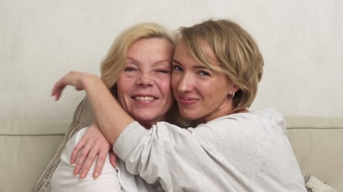 Smiling Mother and Daughter Embrace Affectionately Indoors