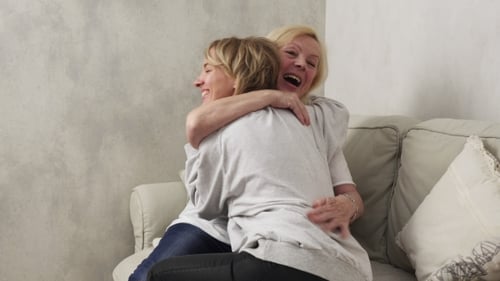 Two Women Sharing a Loving Embrace on Couch