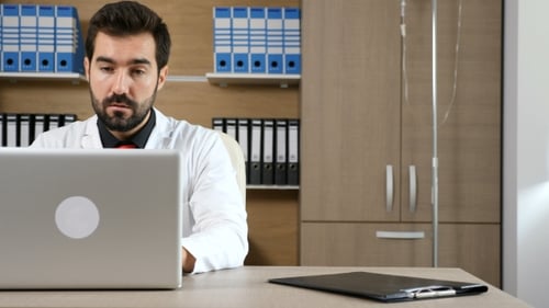 Arzt in seinem Büro am Laptop