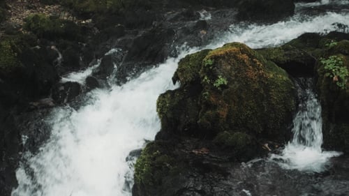 Small Waterfall Flowing Down The Rocks, Mountain River Raging Among The Rocks In The Forest