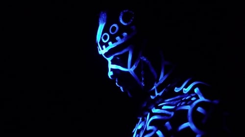 Ein schwarzer Mann in Neonmustern unter ultraviolettem Licht dreht sich um und schaut in die Kamera,