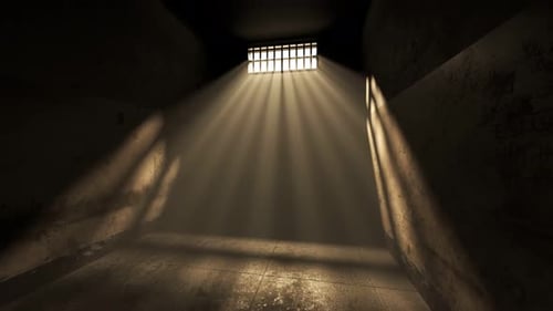 Dunkler alter Zelleninnenraum mit vergittertem Fenster. Sonnenstrahlen kommen durch den Nebel.
