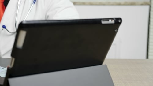 Mains de docteur prenant des notes sur un papier dans son cabinet