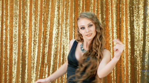 Glamorous Woman Dancing in Front of Gold Sequins