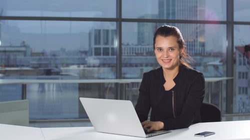 Businesswoman in Office with Laptop Computer.