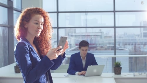 Attractive Woman Using Smart Phone in the Office