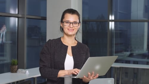 Businesswoman in Office with Laptop Computer.