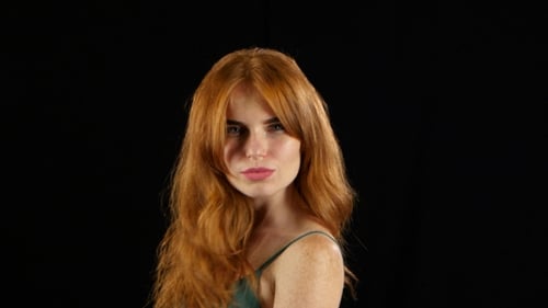 Girl in a Freckle Smiles a Beautiful Smile. Black Background
