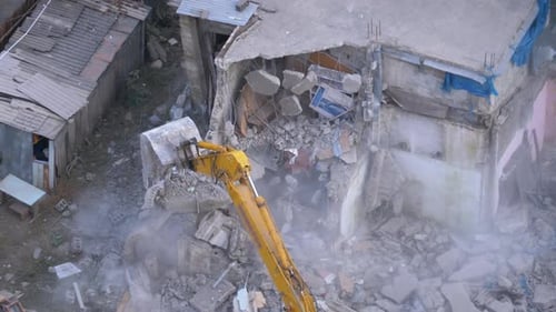Destroying Old Concrete House Using Mechanical Arm of Bulldozer on Construction Site
