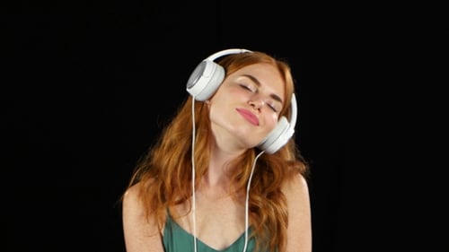 Woman with Headphones Listening to Music on Black