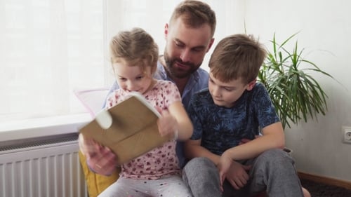 Father and Children Using Tablet Together at Home