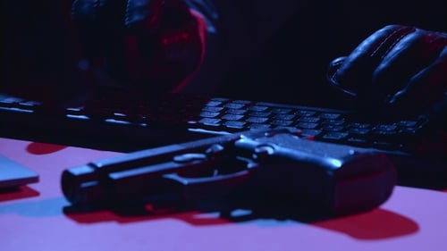 Gloved Hands Typing with a Handgun