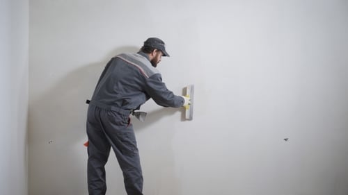 Man Applying Spackle to White Wall