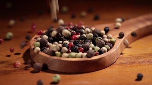 Colorful Peppercorns Falling Into Wooden Spoon, Close Up