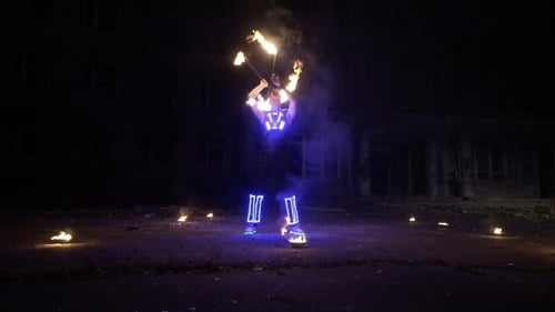 Man Juggling Fire Torches at Night