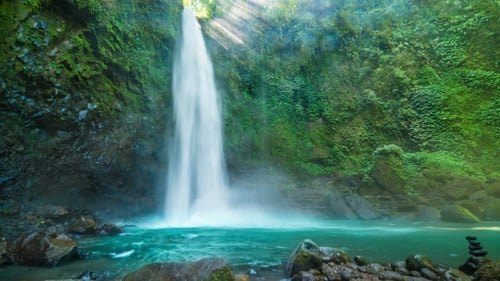 Tropical Waterfall Flowing into Turquoise Pool