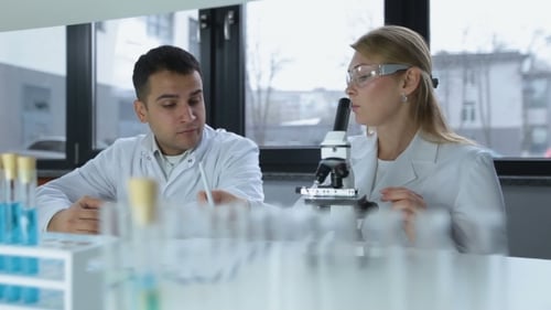 Scientists Working With Microscope in Laboratory