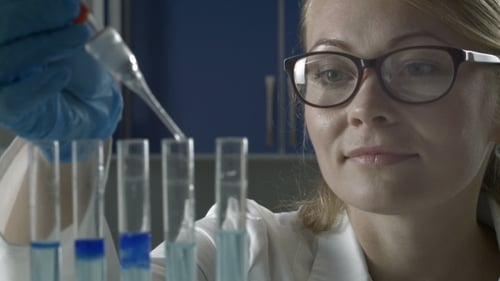 Scientist Using Pipette to Fill Test Tubes