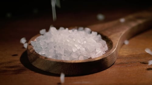 Sea Salt Crystals in Wooden Spoon on a Kitchen Table
