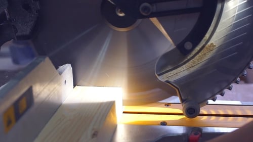 Carpenter Cutting Wooden Plank with Circular Blade Saw