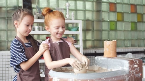 Two Girls Making Pottery Together in Studio