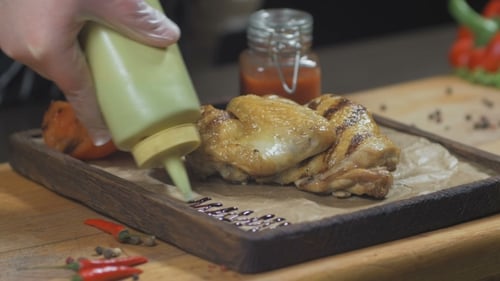 Chicken Being Prepared with Sauce and Vegetables