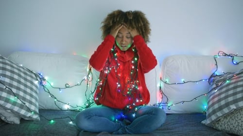 Tired Woman Trying To Untangle Garland
