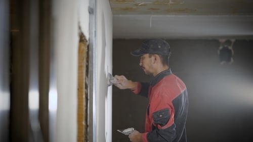Construction Worker Plastering Wall Inside