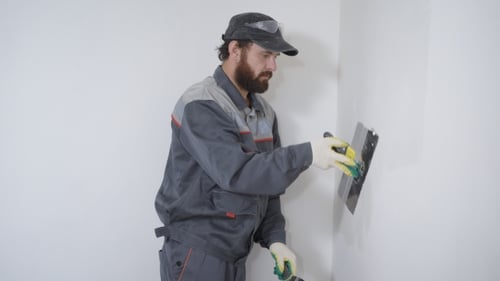 Man Smoothing Plaster on Wall
