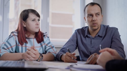 Adults At a Table Signing Paperwork