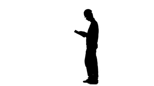Engineer Looks at the Paper Plan of the Building. Silhouette. White Background