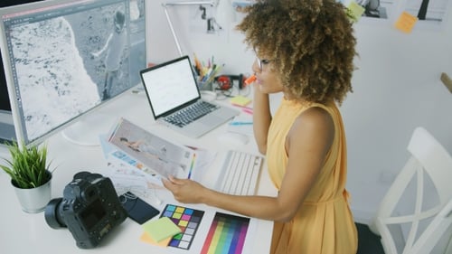 Graphic Designer Working at Bright Desk With Photos