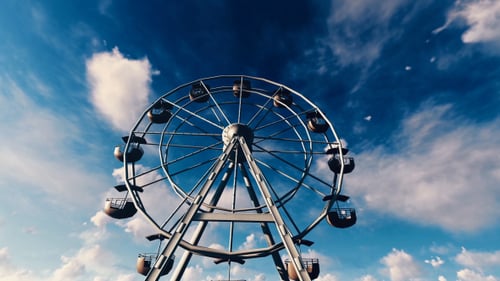 Scenic Ferris Wheel Rotating Against Dynamic Blue Sky