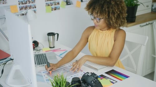 Woman Reviews Images at Her Desk in Bright Office