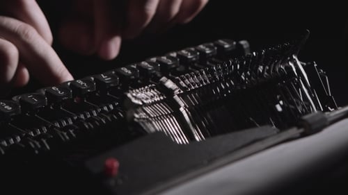 Typing on a Black Antique Typewriter Machine