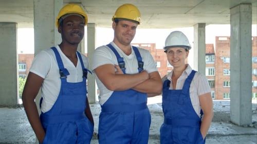 Construction Workers Smile Inside Unfinished Building