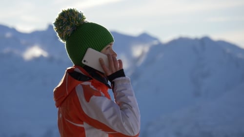 Person on Phone in Snowy Mountain Landscape