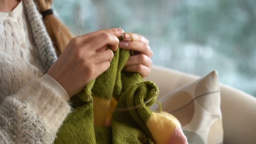 Woman Knitting with Green Yarn Indoors