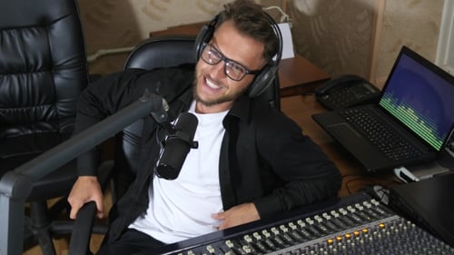 Man Podcasting in Radio Studio Using Microphone