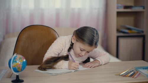 Girl Writing at Desk in Bedroom With Globe