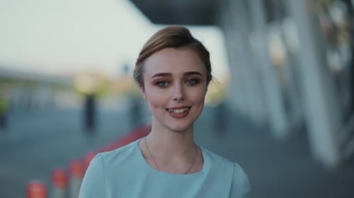 Back View of Young Elegant Woman Walking Down the Street, Then She Turns To Camera and Smiles