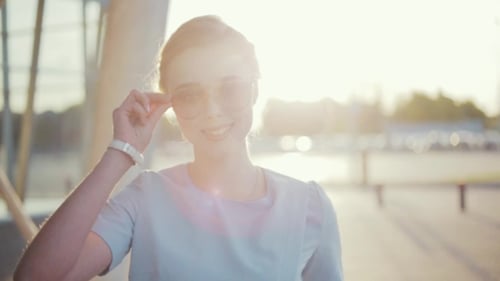 Jovem mulher de negócios andando pela rua sob a luz do sol, então ela se vira para