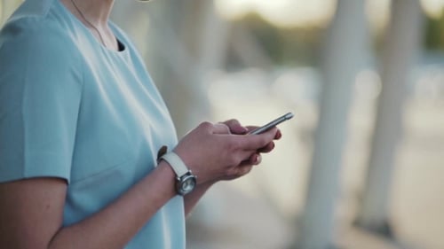 Young Woman Uses Smart Phone in City