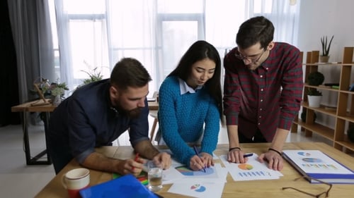 Collaborative Team Analyzing Data Charts in Office