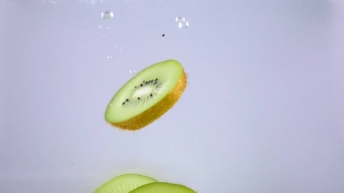 Kiwi Fruit Slices Falling in Water
